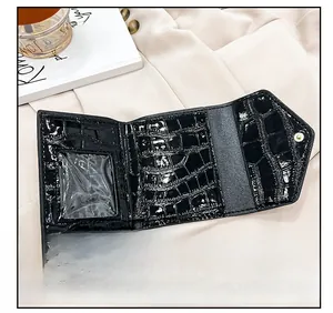 Detail showing the black crocodile pattern texture and card slots of this tri-fold wallet