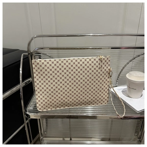 Chic beige handbag with red-brown circular pattern and gold hardware on a wire shelf