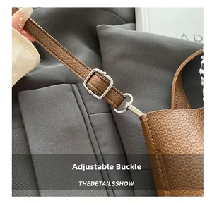 Macro shot of brown pebble leather shoulder strap with silver adjustable metal buckle