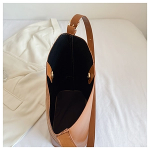 Top view of brown leather bucket bag showing spacious black interior and gold magnetic clasp