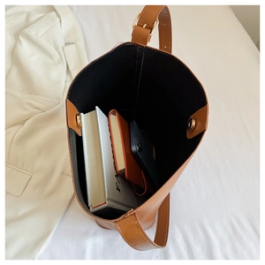 Top view of brown leather bucket bag showing large interior capacity and magnetic closure