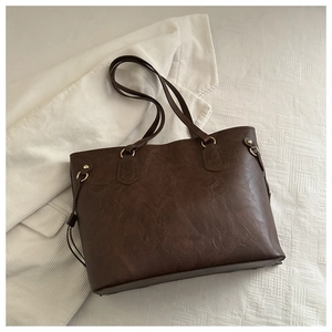 Detail view of large dark brown retro PU leather tote bag with gold metal ring accents
