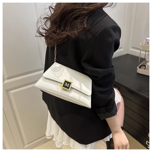Detail of white leather crossbody bag featuring gold M logo buckle and chain strap