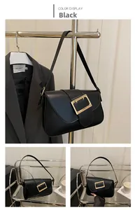 Détail du sac baguette noir en similicuir avec une grande boucle rectangulaire dorée