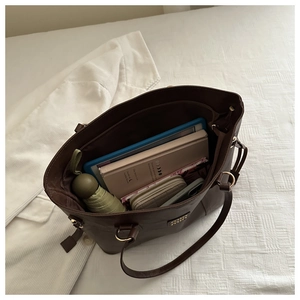 Macro shot of dark brown tote bag showing large capacity for tablet and daily items