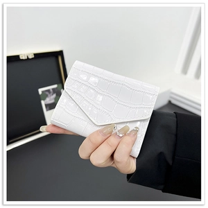 Detail of white crocodile texture leather envelope wallet with glossy patent finish