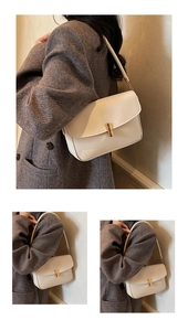 Detail of creamy white rectangular crossbody bag with golden magnetic clasp and smooth finish