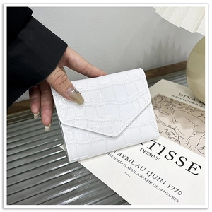 Detail shot of white crocodile embossed envelope card holder held by a hand