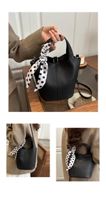 Detail of black lychee grain bucket bag with polka dot scarf and adjustable strap