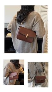 Detail of vintage brown leather handbag with gold metal lock and shoulder chain strap
