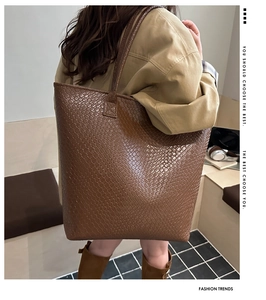 Close-up of a large brown woven tote bag worn by a model for a stylish daily outfit