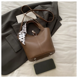 Detailed view of brown lychee grain bucket bag with silk scarf and detachable strap