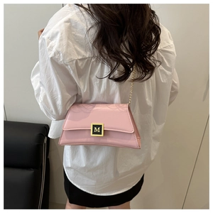 Detailed view of a pink crossbody bag with a gold chain strap and letter M metal buckle