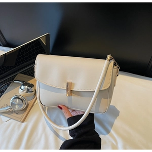 Close-up of cream white shoulder bag featuring gold buckle and chain strap detail