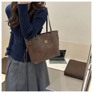 Close-up of vintage brown tote bag with marble texture and gold metallic accents