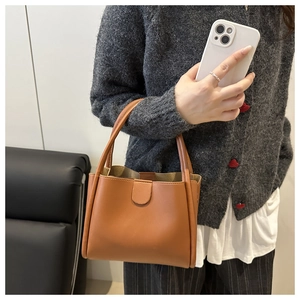 Brown lychee pattern bucket bag detail featuring reinforced stitching and metal buckle
