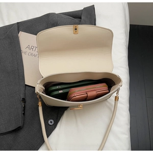 Top view of cream white underarm bag showing interior capacity with gold metal hardware
