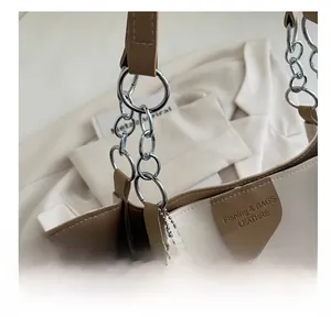 Detail of contrast stitching and silver hardware on a cream and brown tote bag