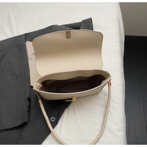 Top view of cream faux leather bag interior showing brown lining and gold twist lock