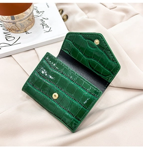 Detail view of dark green stone texture card wallet with metallic snap and black leather lining