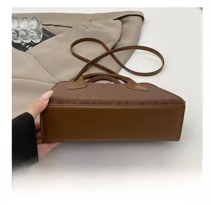 Detailed close-up of the wear-resistant leather base on this large brown handbag