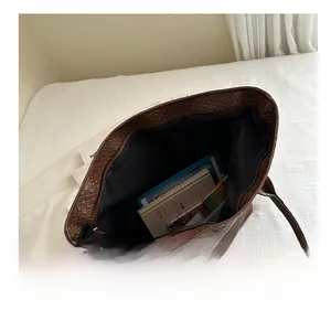 Macro detail of spacious brown woven tote bag interior showing zipper and large capacity