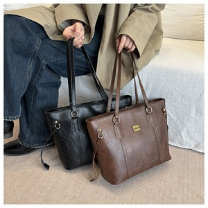 Detail of vintage textured PU leather tote bag featuring gold ring strap connectors