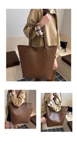 Detail of dark brown woven tote bag showing the textured surface and reinforced stitching