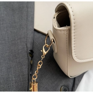 Detailed close-up of cream white PU leather bag with premium gold chain and lobster clasp