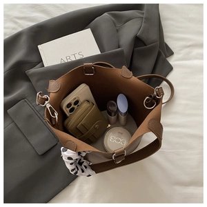 Inside view of brown litchi pattern bucket bag showing large capacity and silk scarf detail