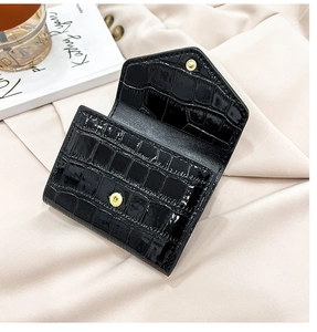 Detail of black faux crocodile leather mini card holder with gold metal snap closure