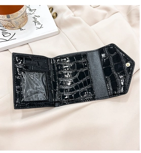 Detail view of black crocodile pattern wallet with clear ID window and snap closure