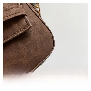 Detailed close-up showing precision stitching on dark brown matte suede shoulder bag