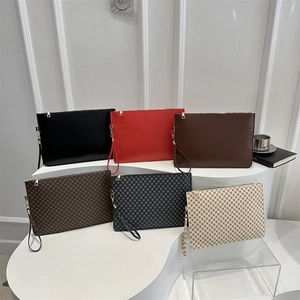 Minimalist square wristlet clutches in solid colors and checkered patterns displayed on steps