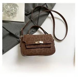 Detail showing brown leopard print texture and golden metal lock on the French Kelly bag