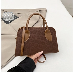Dettaglio borsa vintage con stampa leopardata, patchwork in pelle e doppi manici
