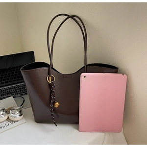 Brown leather tote bag next to a pink tablet showing a spacious interior for a 10 inch device