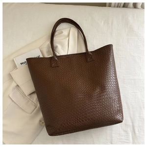 Close-up of brown woven texture and slim handles on this large capacity tote bag