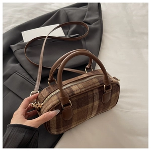 Dettaglio della borsa a mano vintage a quadri in lana marrone con manici in pelle e metallo oro