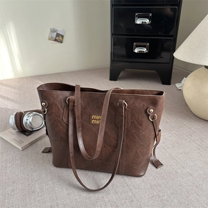 Chic brown vintage textured leather tote bag with metal logo and stylish drawstring
