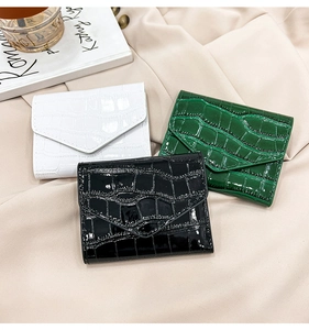 Detailed display of crocodile pattern wallets in white, black and dark green