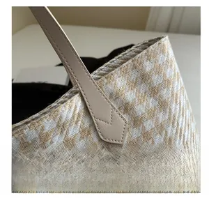 Close-up of contrast woven herringbone tote bag with premium leather handles and V-shaped stitching
