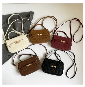 Flat lay view of leopard print Kelly bags in five colors with golden twist lock hardware