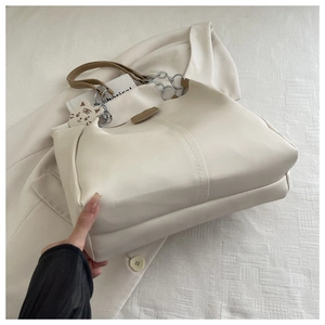 Creamy white tote bag featuring quilted texture and a cute tiger charm detail