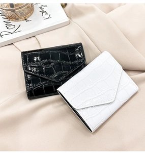 Detail of minimalist stone pattern wallets in black and white with crocodile texture