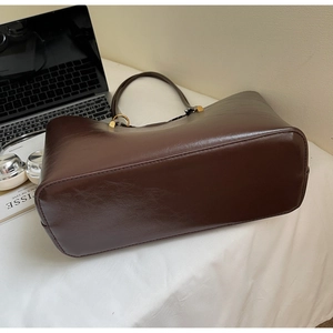 Detail of spacious dark brown tote bag base with premium oil wax leather and stitching
