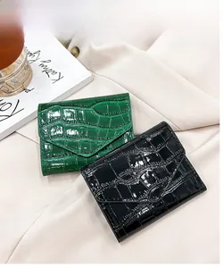 Detail of elegant crocodile-patterned card holders in deep green and black faux leather