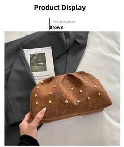 Dettaglio di una pochette marrone leopardata in velluto con decorazioni di borchie dorate