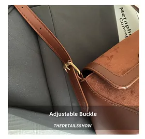Macro detail of golden metal adjustment buckle on brown faux leather shoulder bag