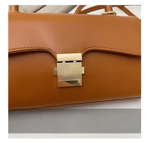 Gros plan sur la boucle en métal doré et le cuir texturé du sac couleur caramel